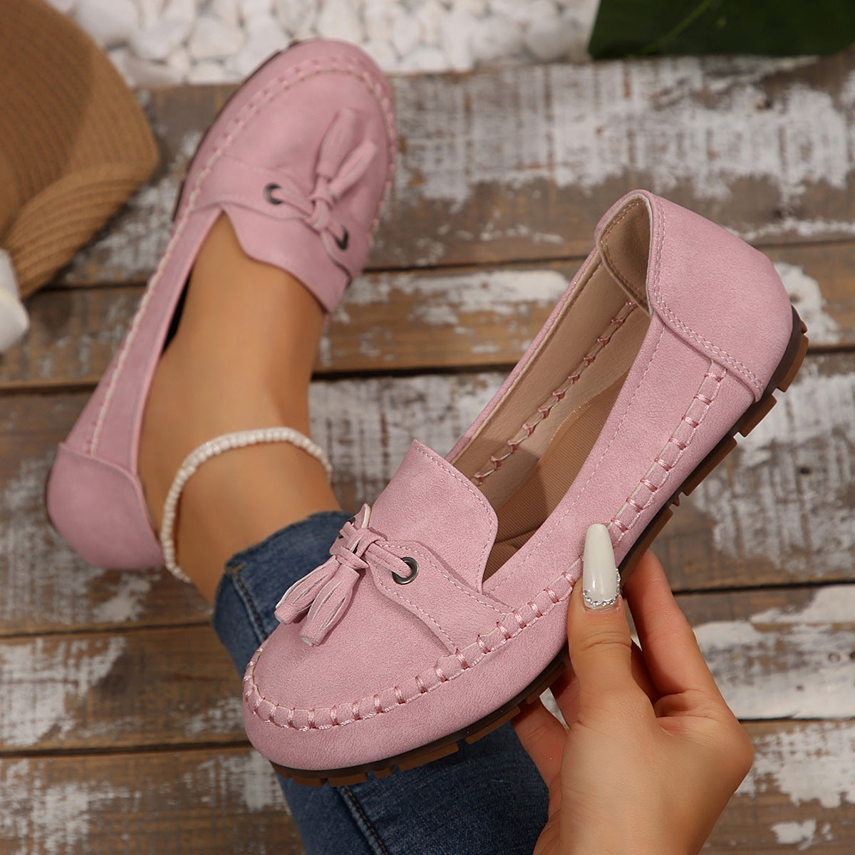 Pink tassel loafer in hand