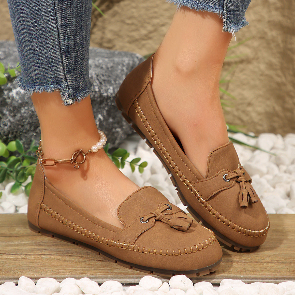 Brown faux-suede tassel loafer on foot